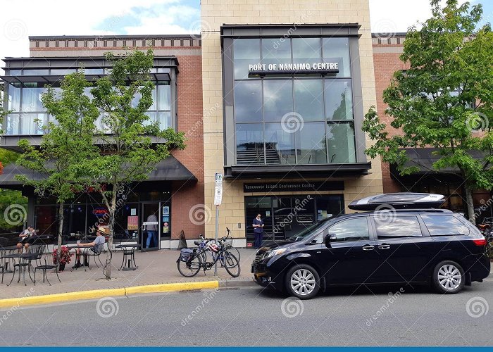 Vancouver Island Conference Centre Black SUV Parked on a Street in Front of a Modern Building ... photo